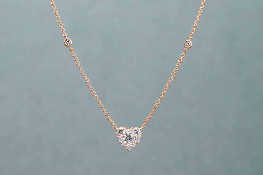 A Gold and White necklace with a heart-shaped pendant 