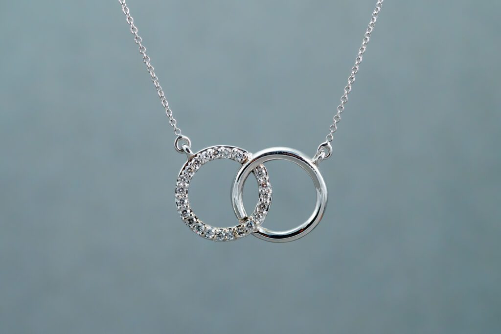 A Silver necklace with two interlocked mid-sized rings as pendants
