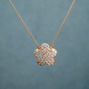 A necklace with a clover-shaped pendant filled with White gemstones 