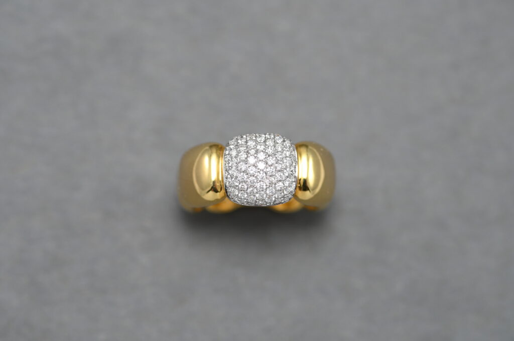 A Gold ring with a pendant filled with a handful of Diamonds 