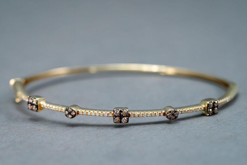 A Gold bracelet with some Pink pendants 