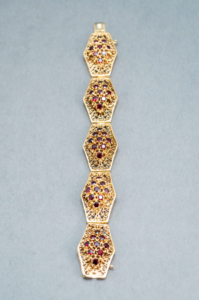 A long chain with different colored stones on it.
