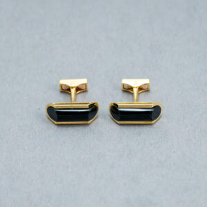 A pair of cufflinks with black stones on top.