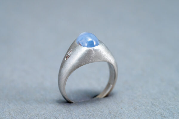 A silver ring with a blue stone on it