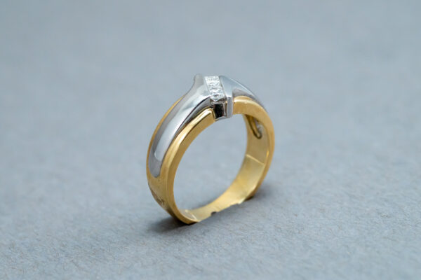 A gold and silver ring with a diamond on it.