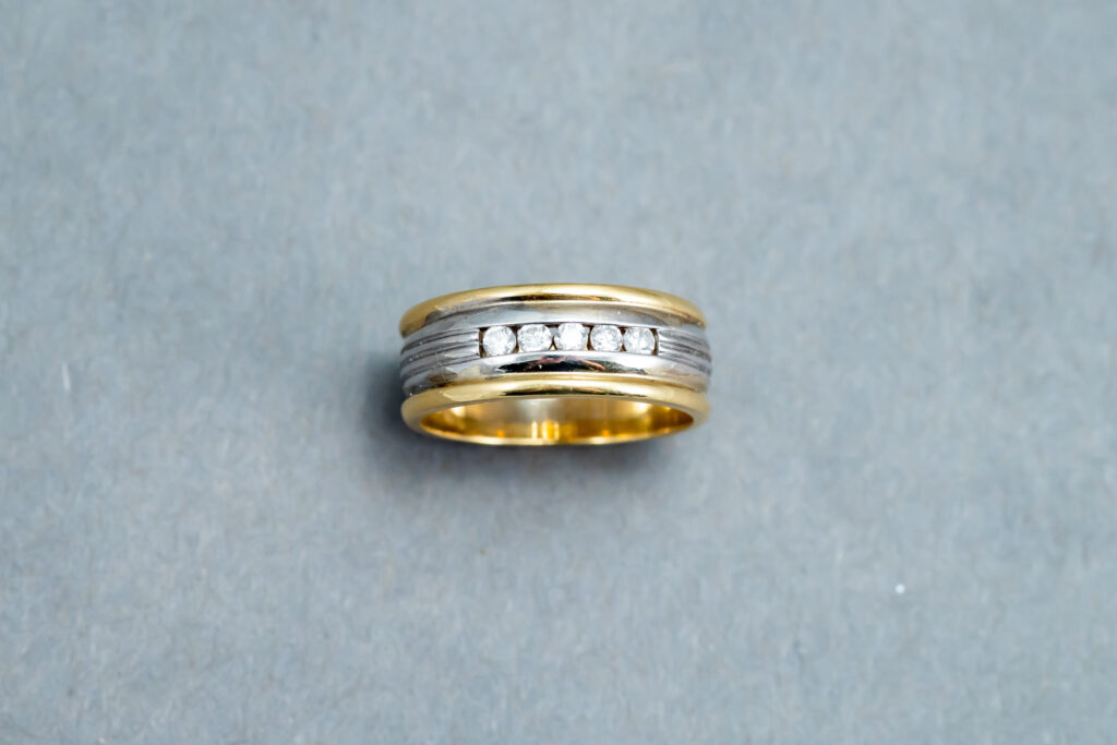 A gold and silver ring with diamonds on it.