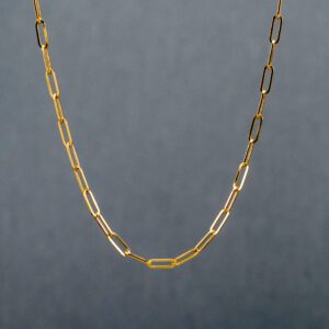 A close up of a chain necklace on a gray background