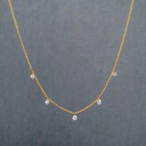 A gold chain with five diamonds on it.
