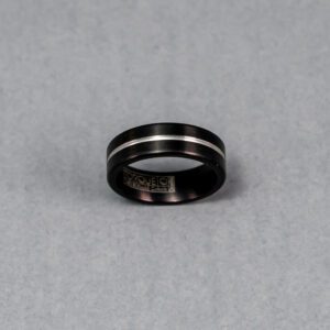 A black and silver ring is shown on the ground.