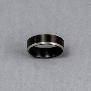 A black and silver ring is shown on the ground.