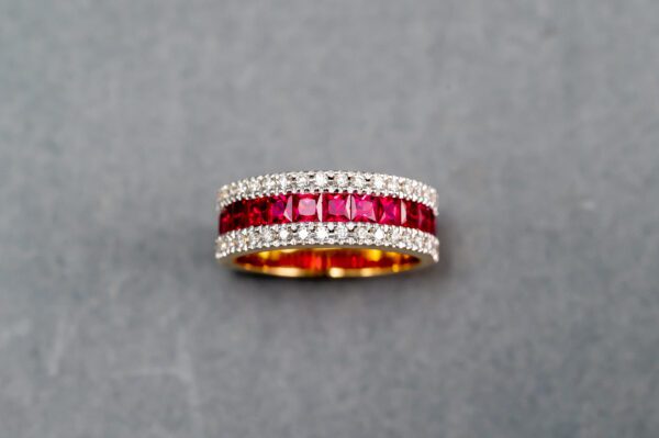 A gold ring with red and white stones
