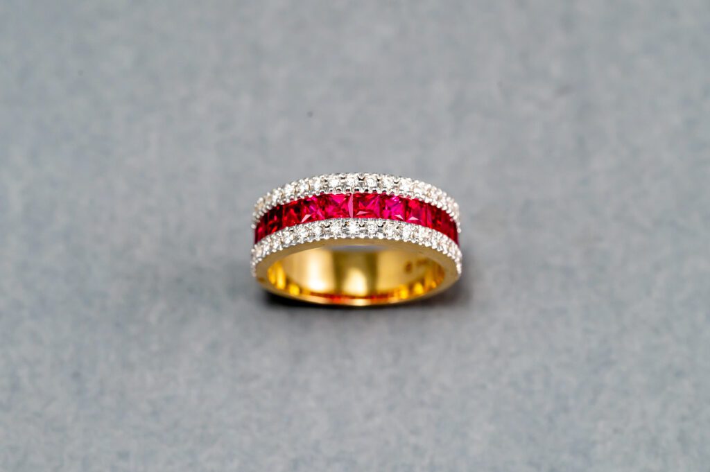 A gold ring with red and white stones on it