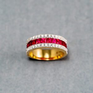 A gold ring with red and white stones on it