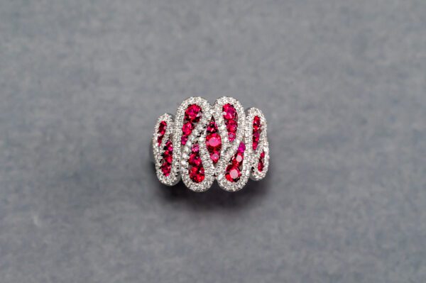 A silver ring with red stones on it.