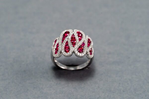 A silver ring with red stones on it's side.