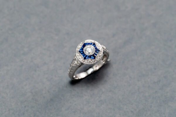 A diamond and blue stone ring is shown.