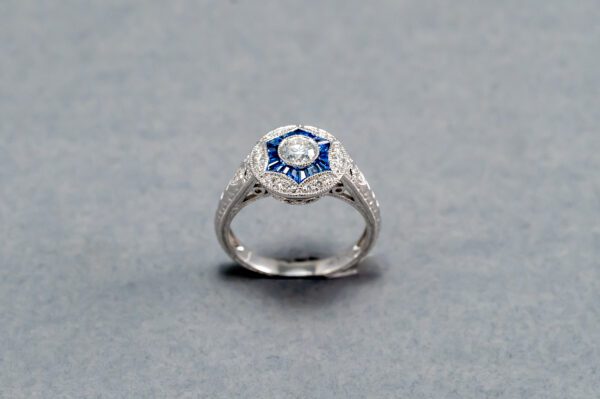 A diamond and blue stone ring on top of a white surface.