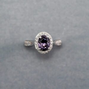 A purple diamond ring is shown on top of a gray background.