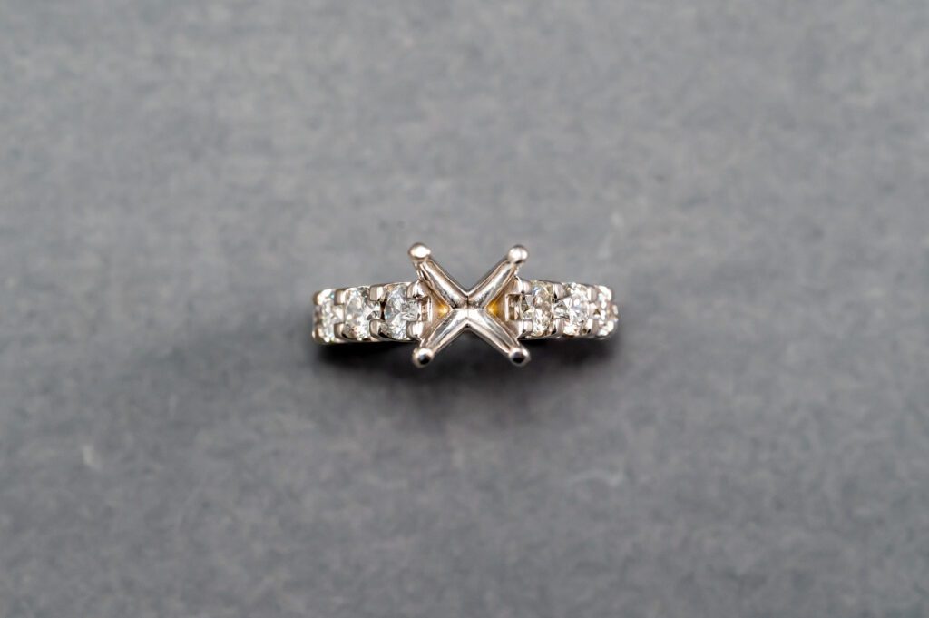 A diamond ring with a square cut stone on it.