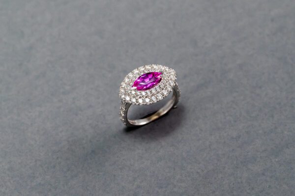 A pink diamond ring with white diamonds on it.