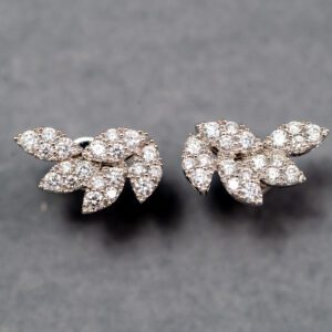 A pair of diamond earrings with a leaf design.