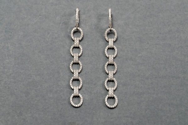 A pair of silver earrings with a long chain.