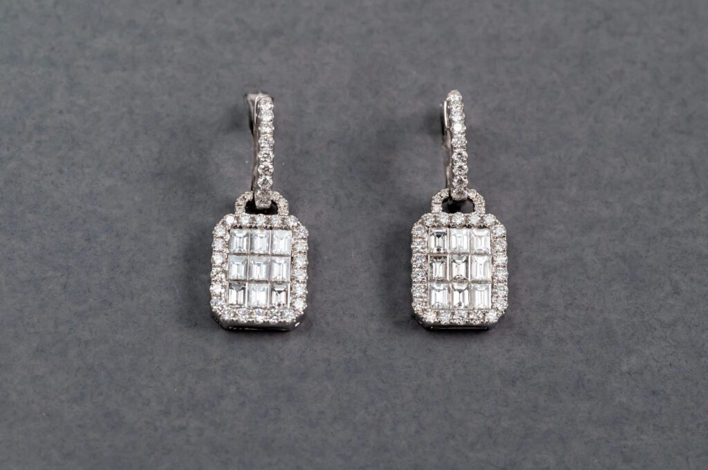 A pair of diamond earrings with square cut diamonds.