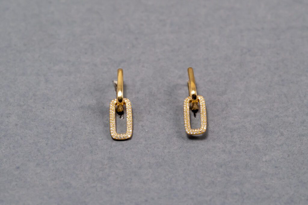 A pair of gold earrings with a rectangular design.