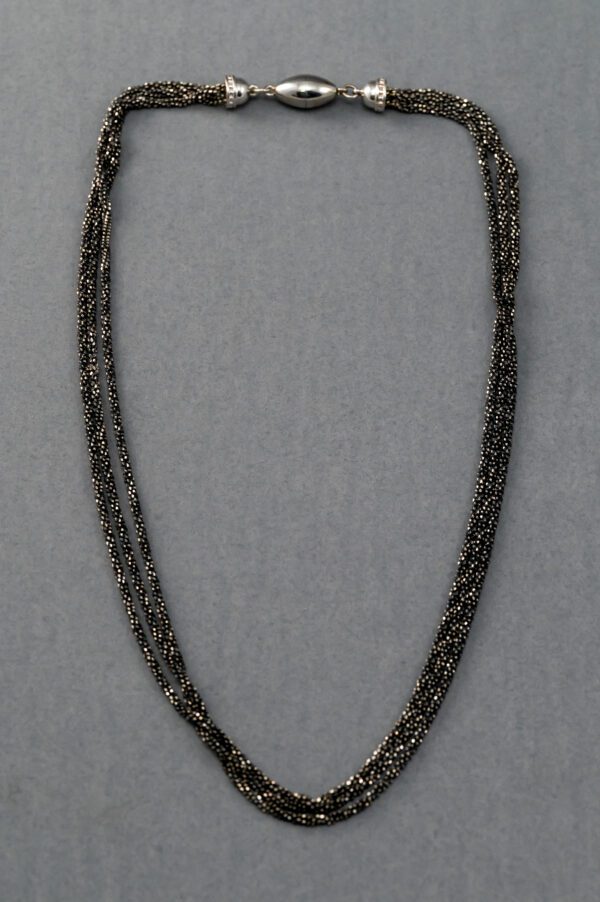 A necklace with three strands of black beads.