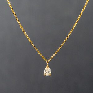 A gold chain with a diamond on it