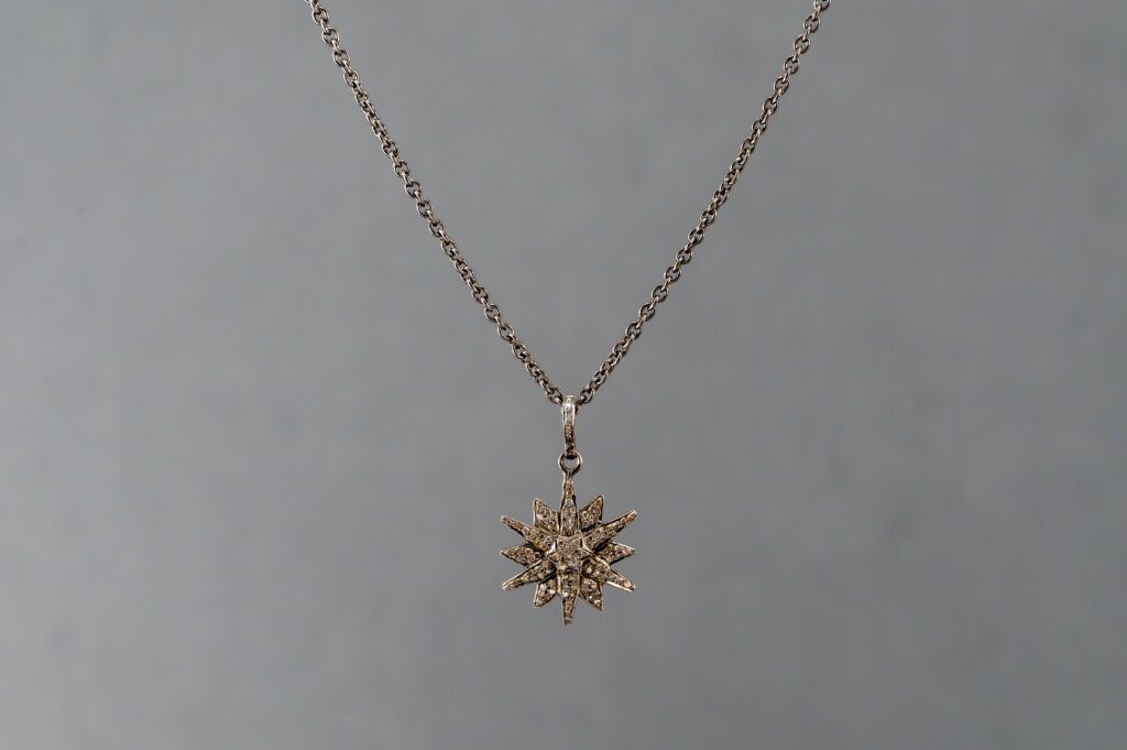A silver necklace with a gold chain and a pendant.
