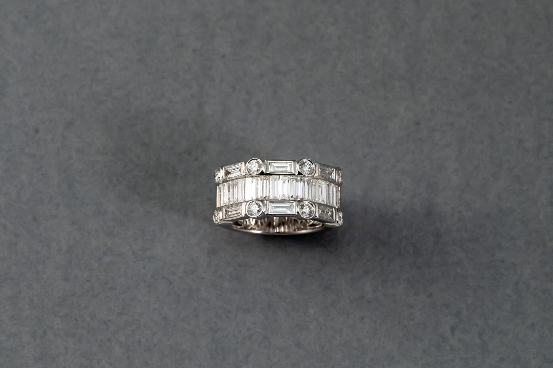 A silver ring with many small diamonds on it