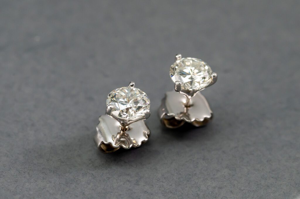A pair of diamond earrings on top of a table.