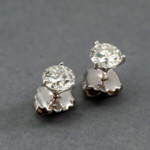 A pair of diamond earrings on top of a table.