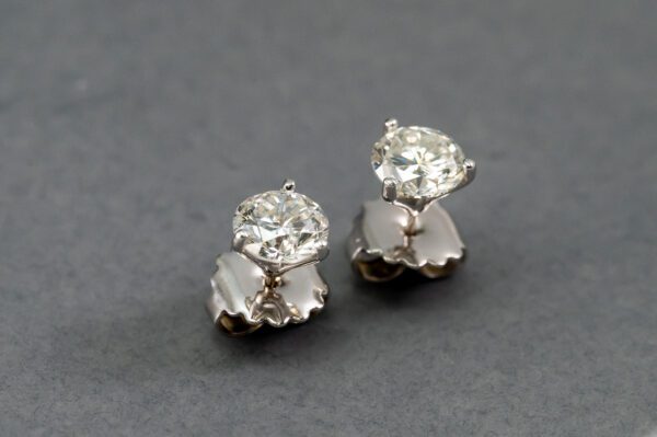 A pair of diamond earrings on top of a table.