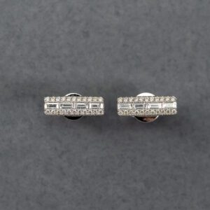 A pair of silver earrings with diamonds on top.