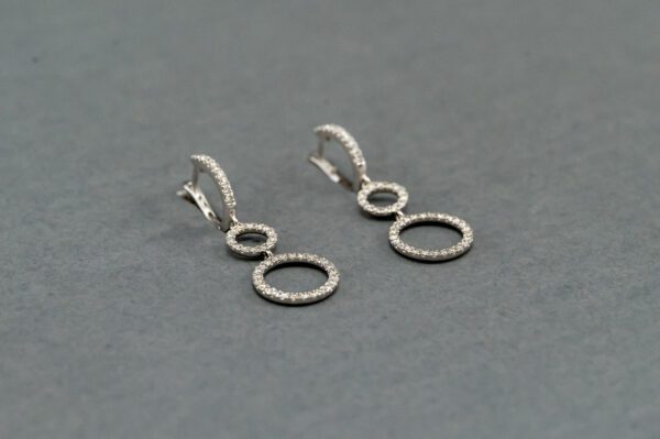 A pair of silver earrings with two circles and one circle.