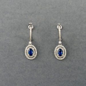 A pair of earrings with blue stones and white diamonds.