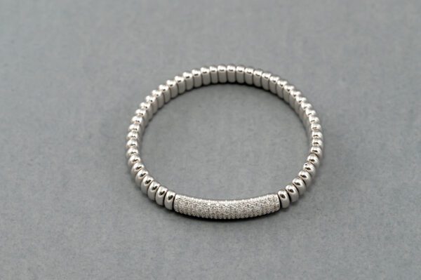 A silver bracelet with a bar on it.