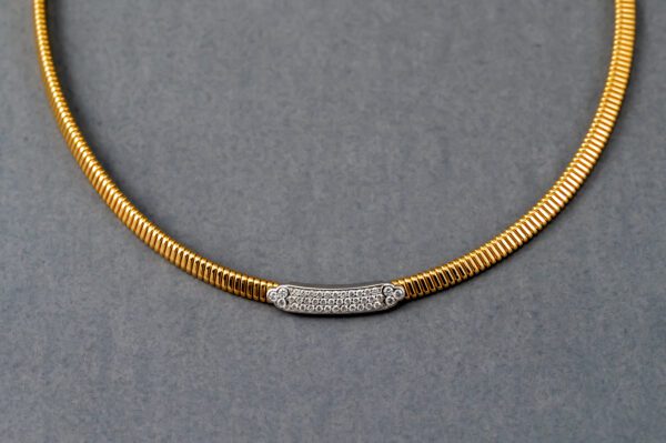 A gold necklace with a diamond bar on it.