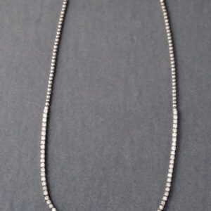 A long silver chain with a small bead on it.