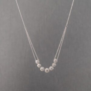 A silver necklace with seven beads on it.