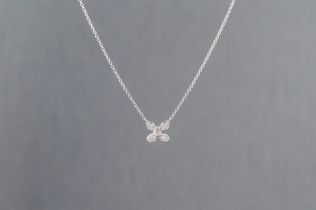 A silver necklace with four small diamonds on it.
