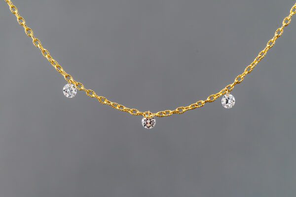 A gold chain with three small diamond dangling from it.