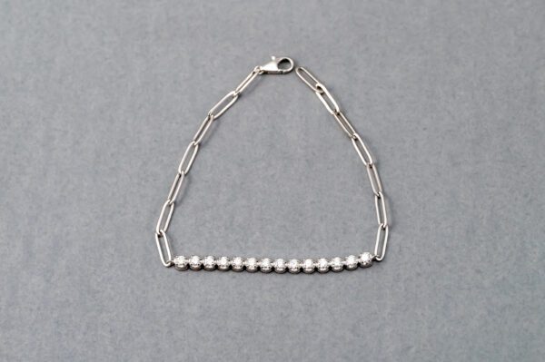 A silver chain bracelet with pearls on it.