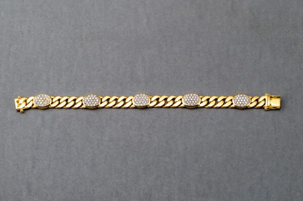 A gold chain with five oval shaped diamonds on it.
