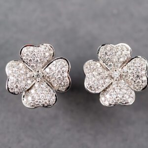 A pair of earrings with four leaf clover shaped diamonds.