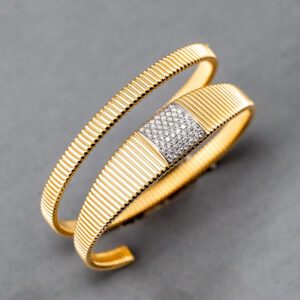 A gold bracelet with diamonds on it's side.