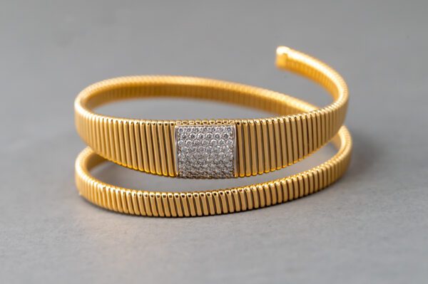 A gold bracelet with a diamond square on it.