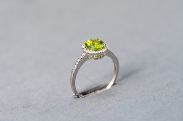 A silver ring with a green stone on top of it.